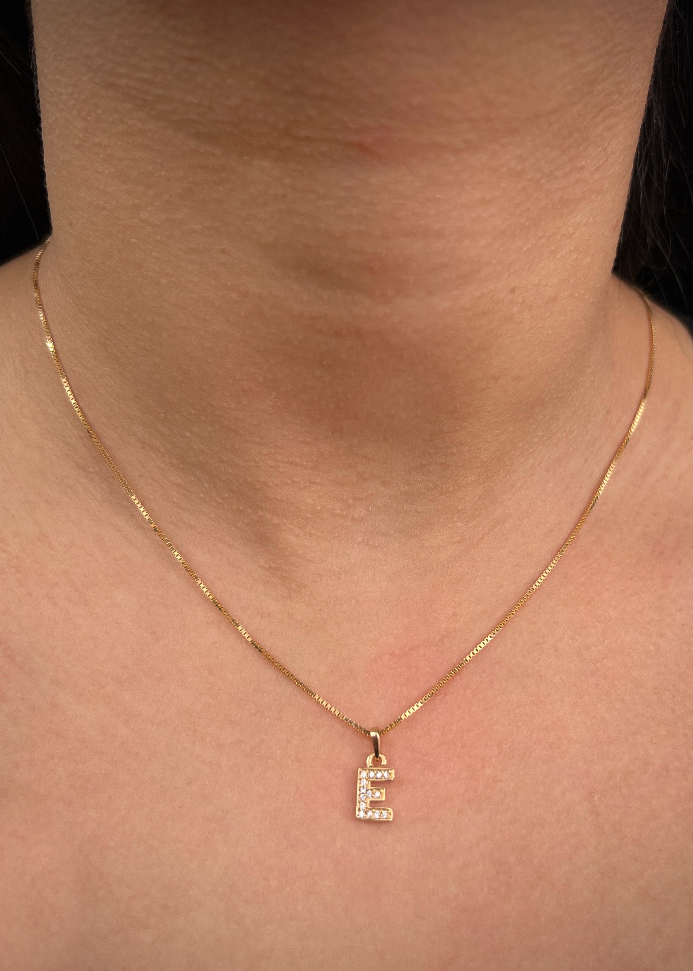 Dije letra e con swarovski blanco 0.85gr / Largo 1.4cm / Oro Amarillo Nac B