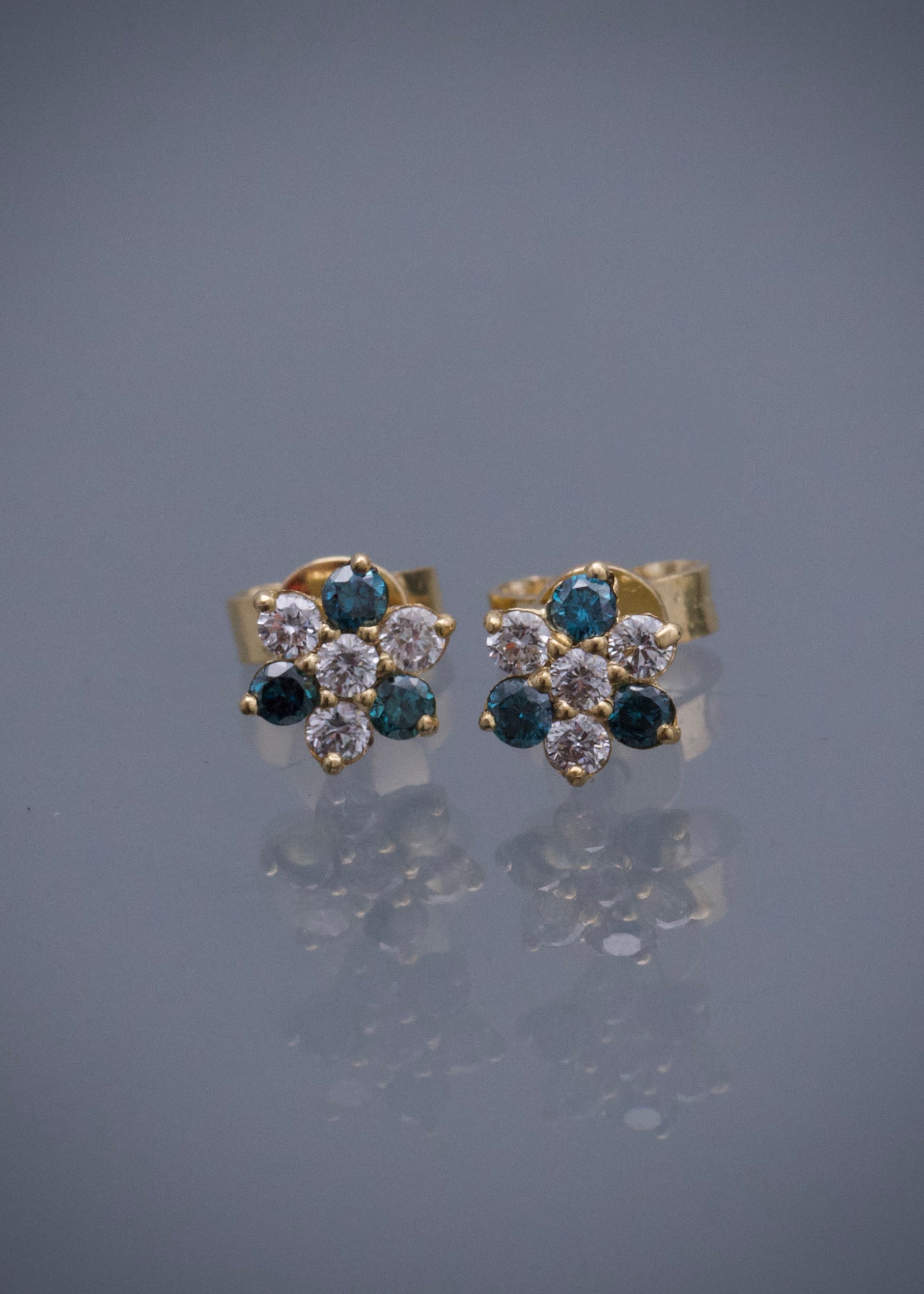 Topos flor con 17pts de diamante blanco y 14pts de diamante azul 1.2gr / Largo 0.55cm / Oro Amarillo (Joya) B