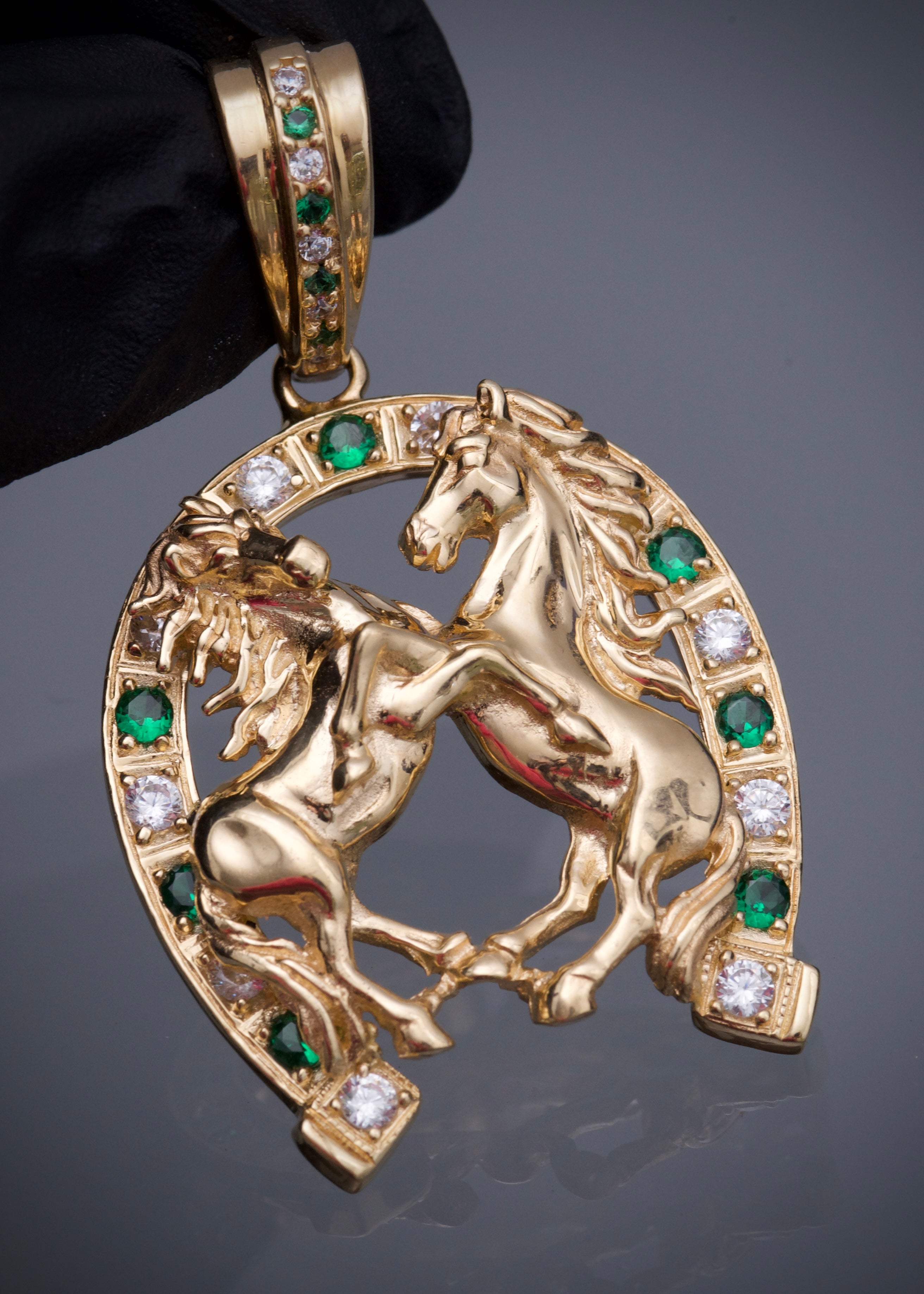 Dije herradura y caballos con swarovski blanco y verde 13.15gr / Largo 5.2cm / Oro Amarillo Nac M