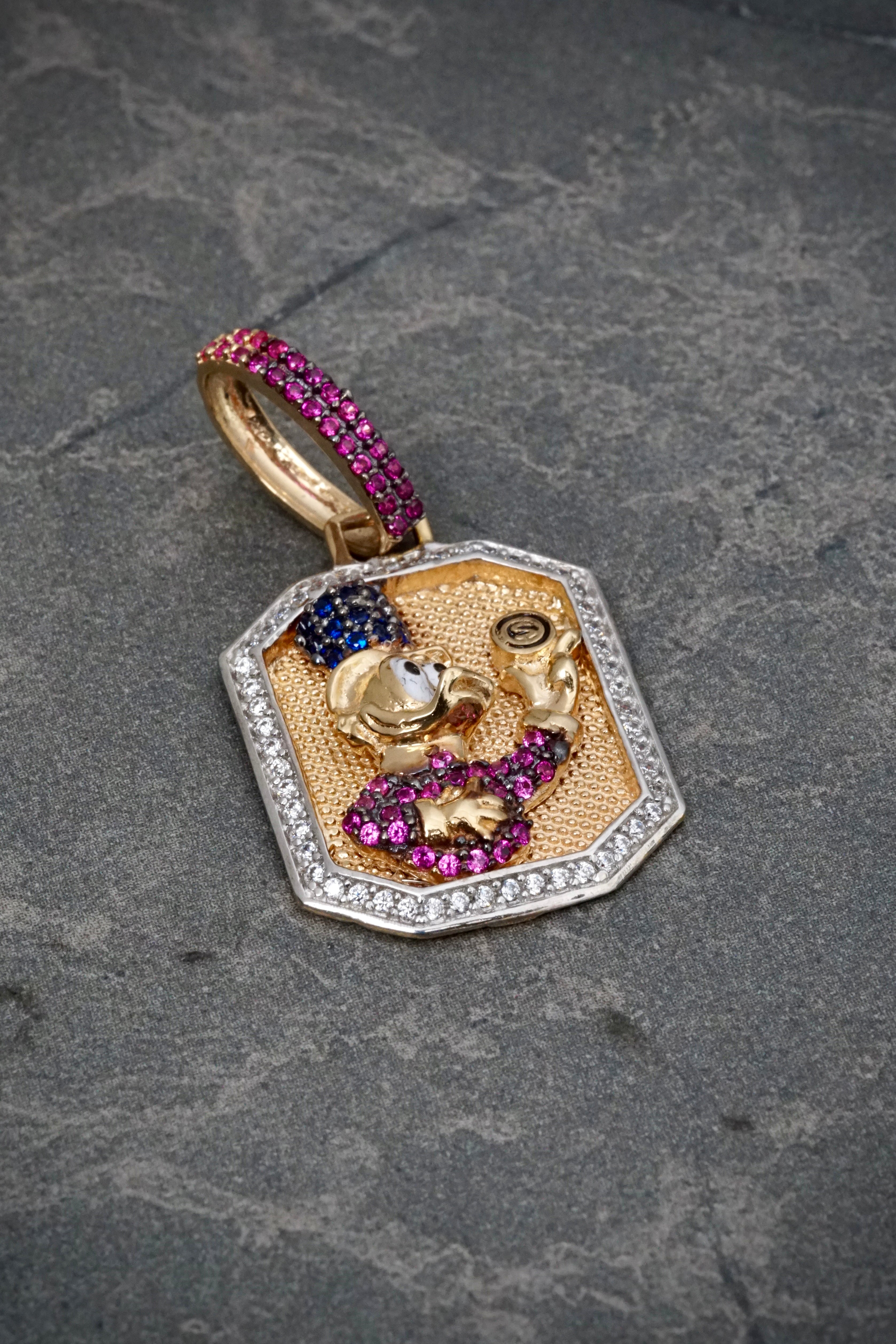 Dije tio rico con swarovski fucsia y blanco 6.55gr / Largo 3.6cm / Oro Amarillo Nac B