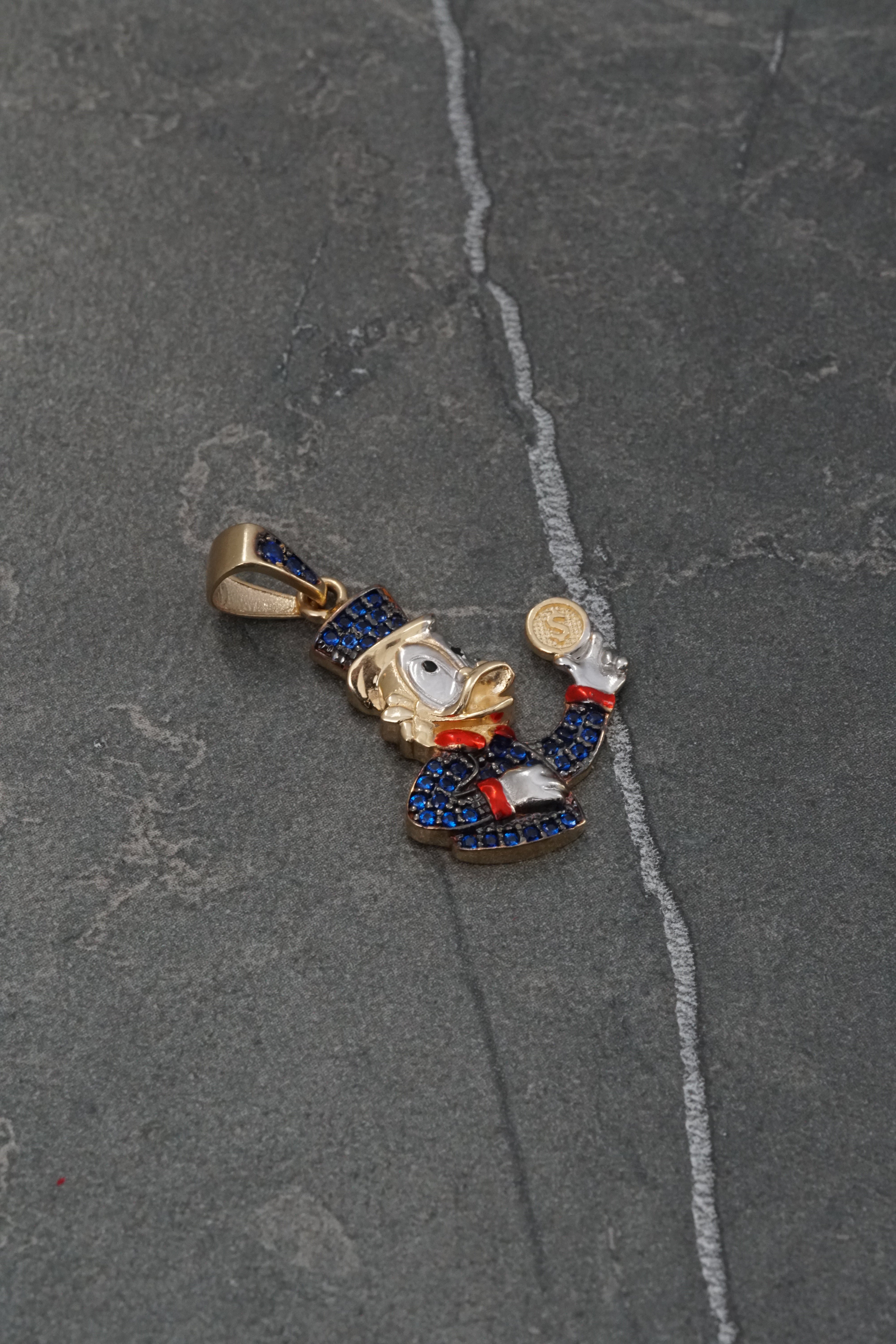 Dije tio rico con swarovski azul 3.45gr / Largo 3cm / Oro Amarillo Nac M