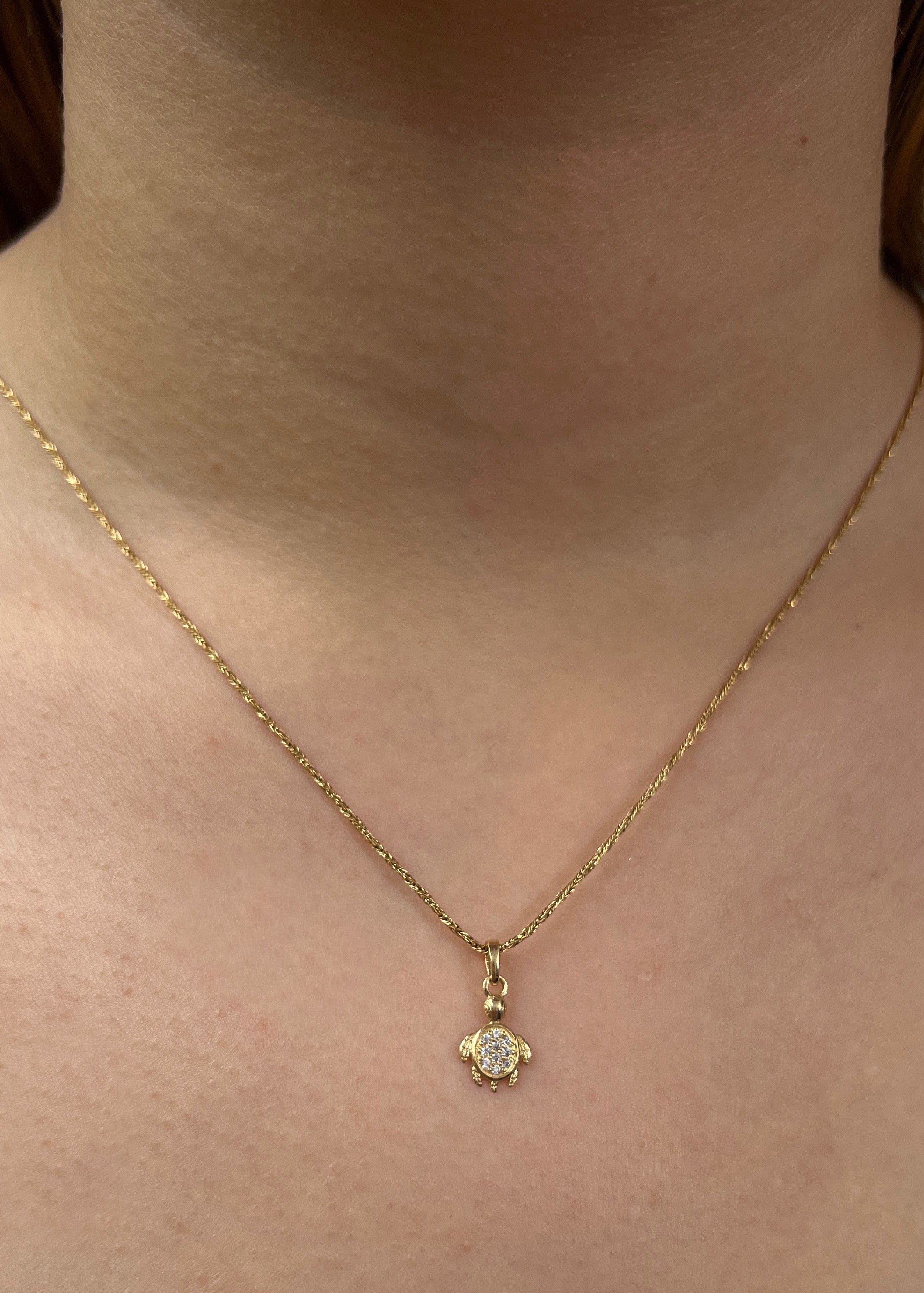 Dije tortuga con swarovski blanco 0.6gr / largo 1.5cm / Oro Amarillo Nac*