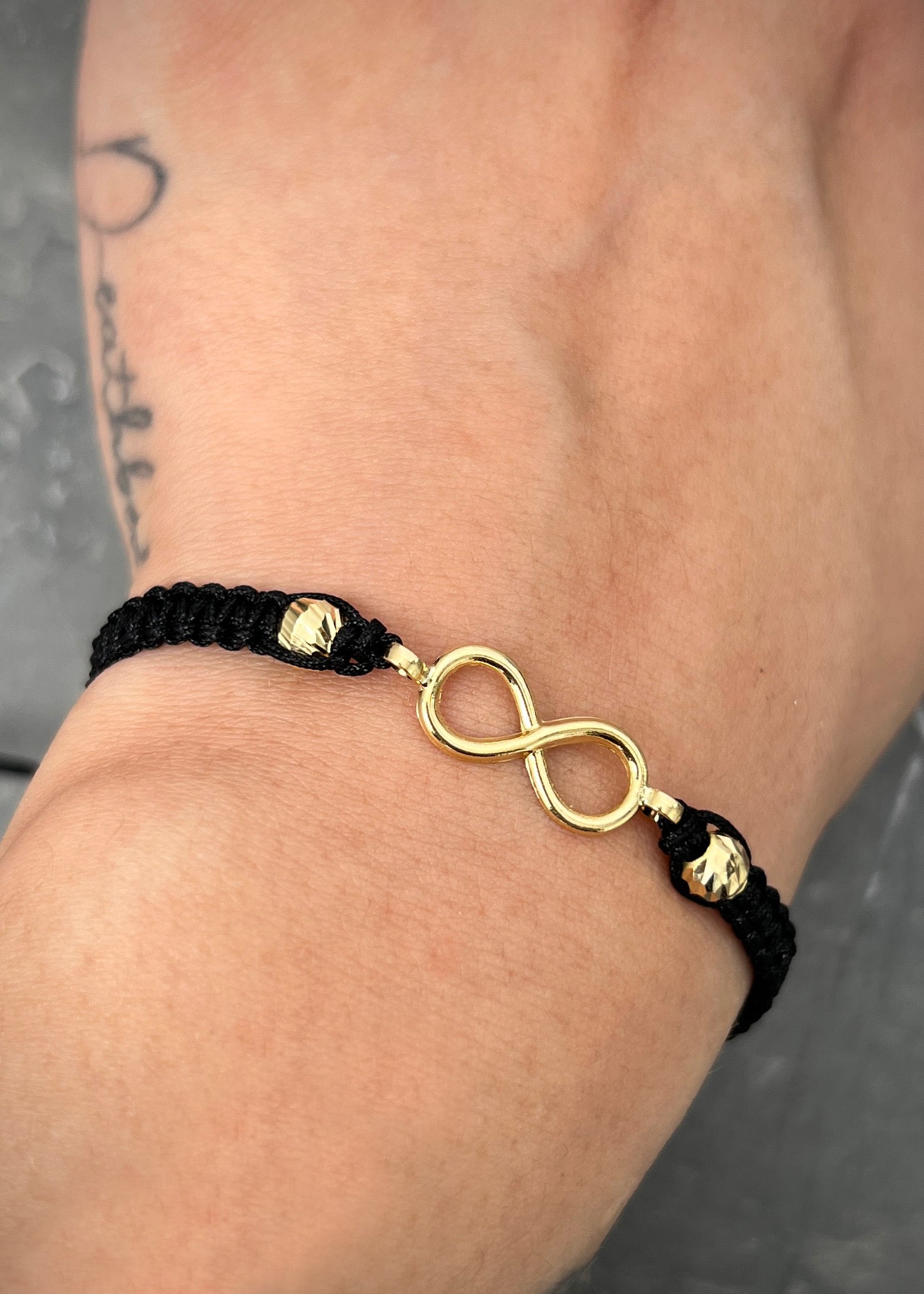 Pulsera en hilo negro con herraje infinito 0.8gr / Oro Amarillo (Joya) M