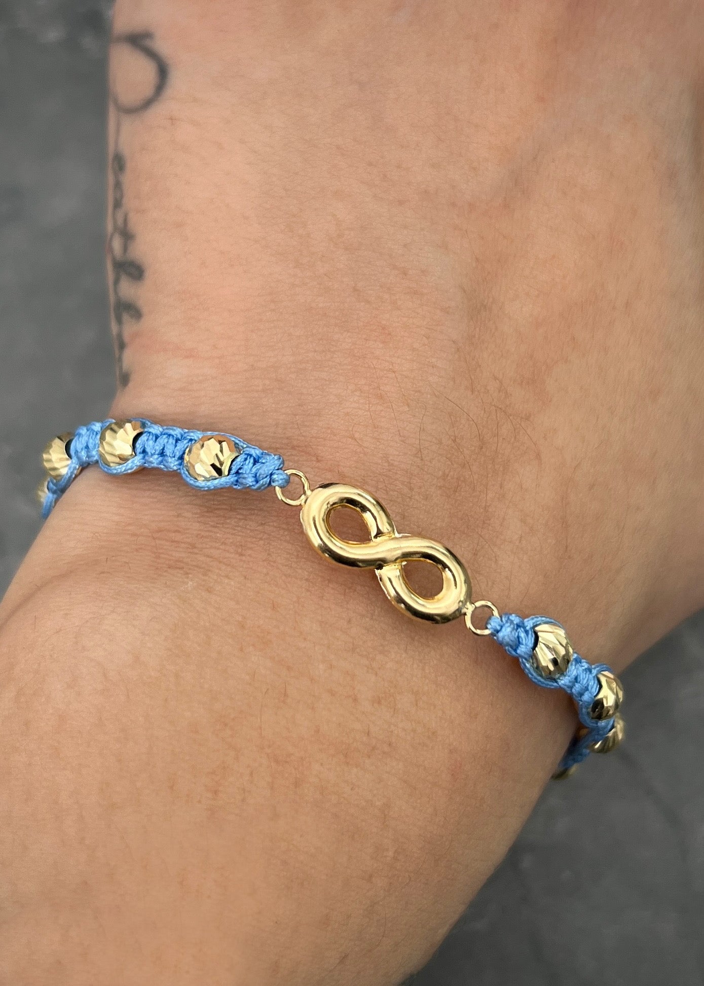 Pulsera en hilo azul con herraje de infinito 1.75gr / Oro Amarillo (Joya) M