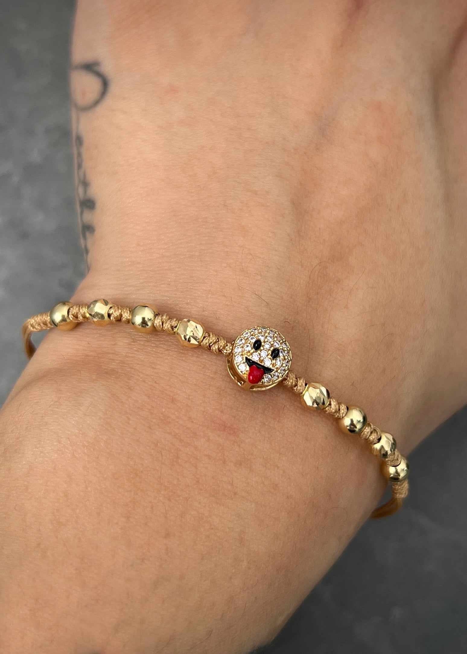 Pulsera en hilo beige con herraje carita 1.5gr / Oro Amarillo (Joya) M