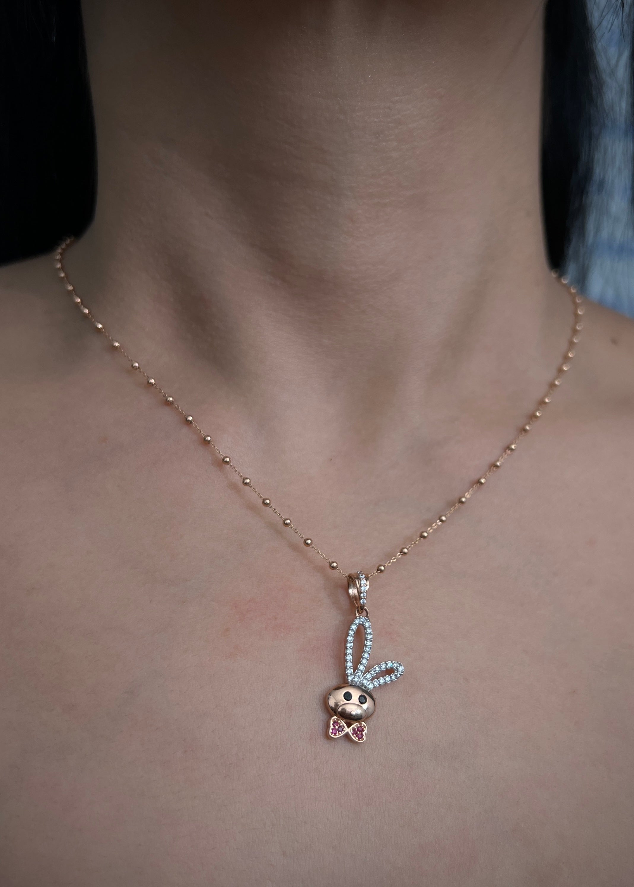 Dije conejo con swarovski fucsia y blanco 2.25gr / Largo 3.1cm / Oro Rosado Nac B