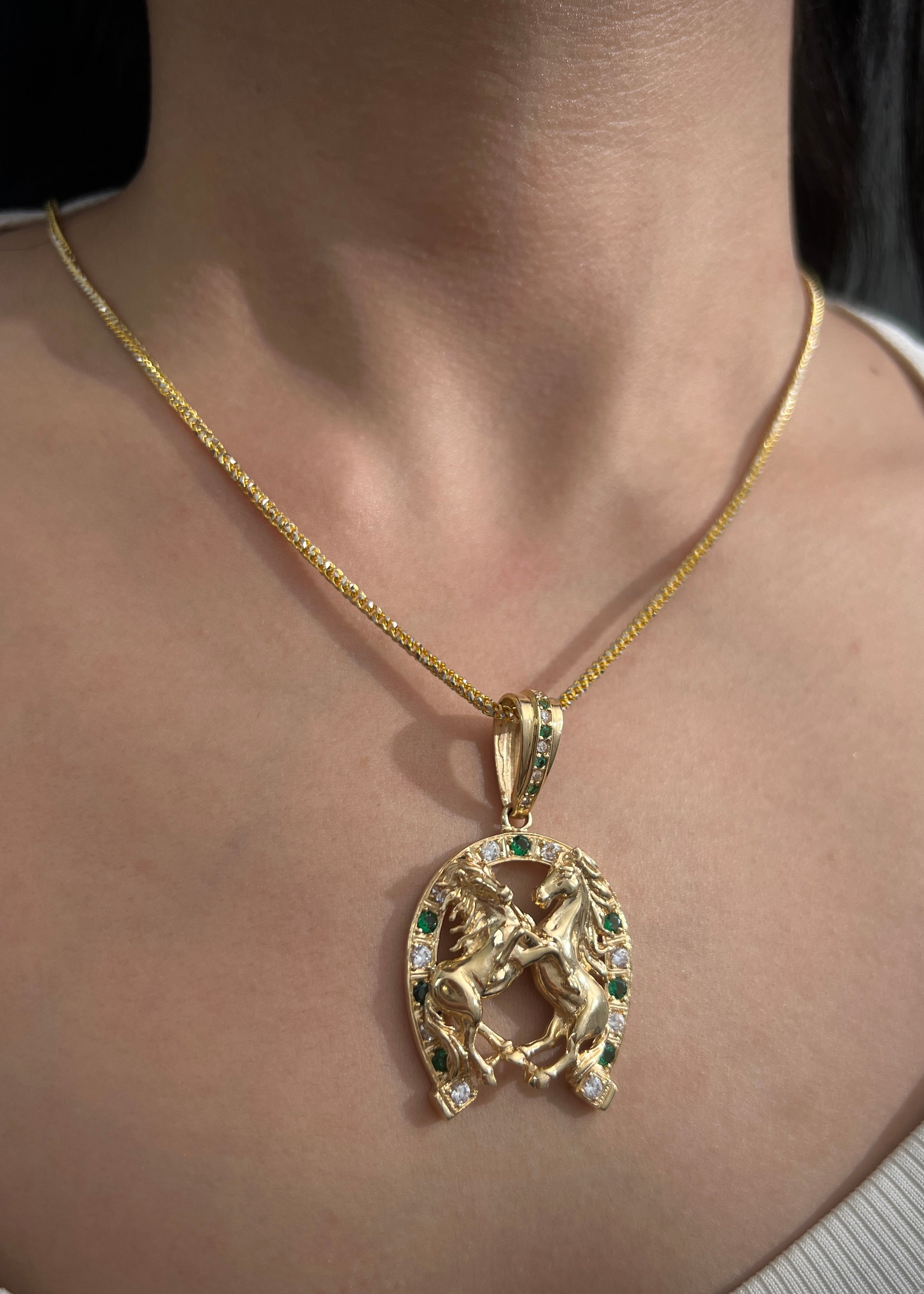 Dije herradura y caballos con swarovski blanco y verde 13.15gr / Largo 5.2cm / Oro Amarillo Nac M