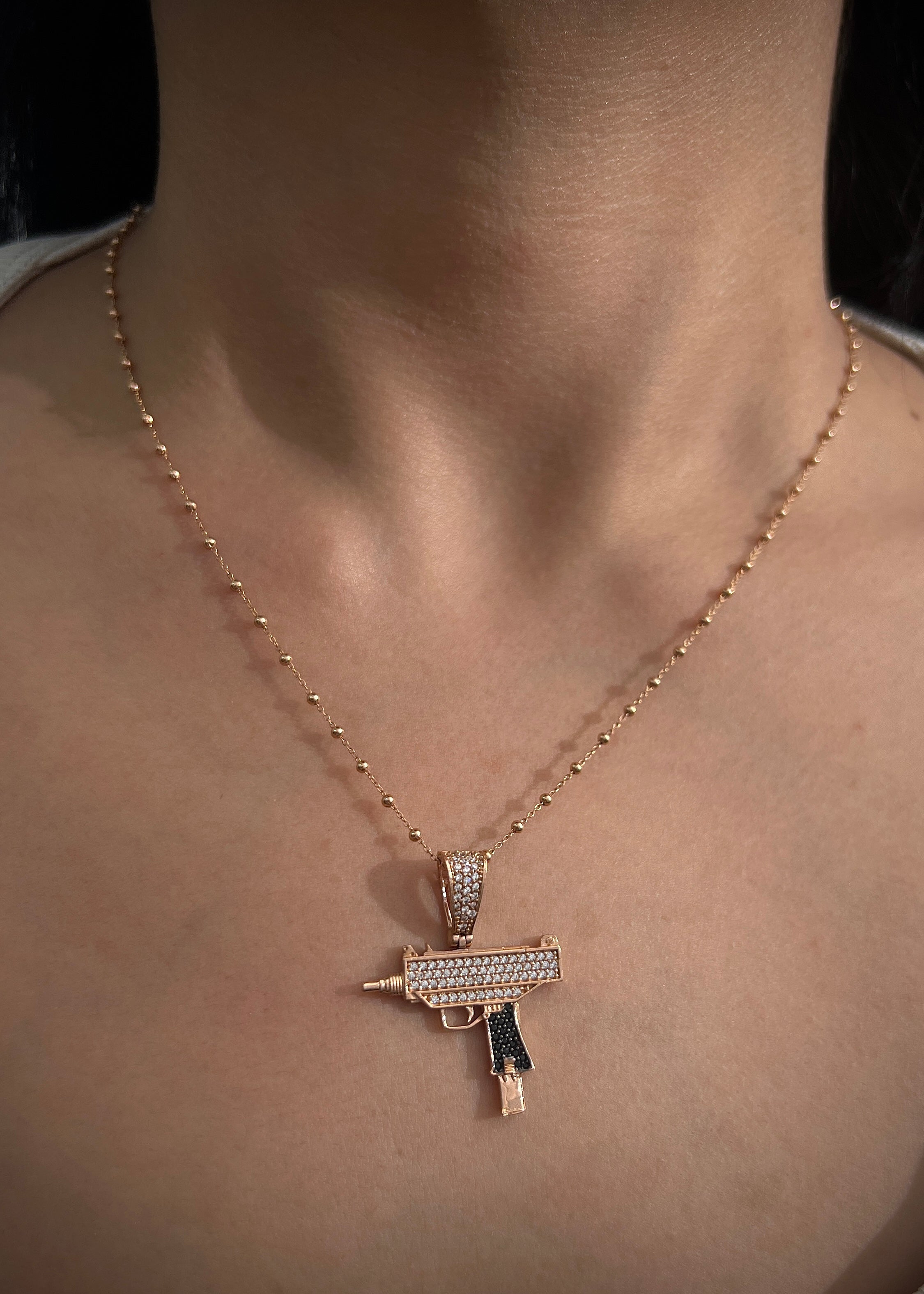 Dije mini uzi swarovski negro y blanco 3.85gr / Largo 3.4cm / Oro Rosado Nac M