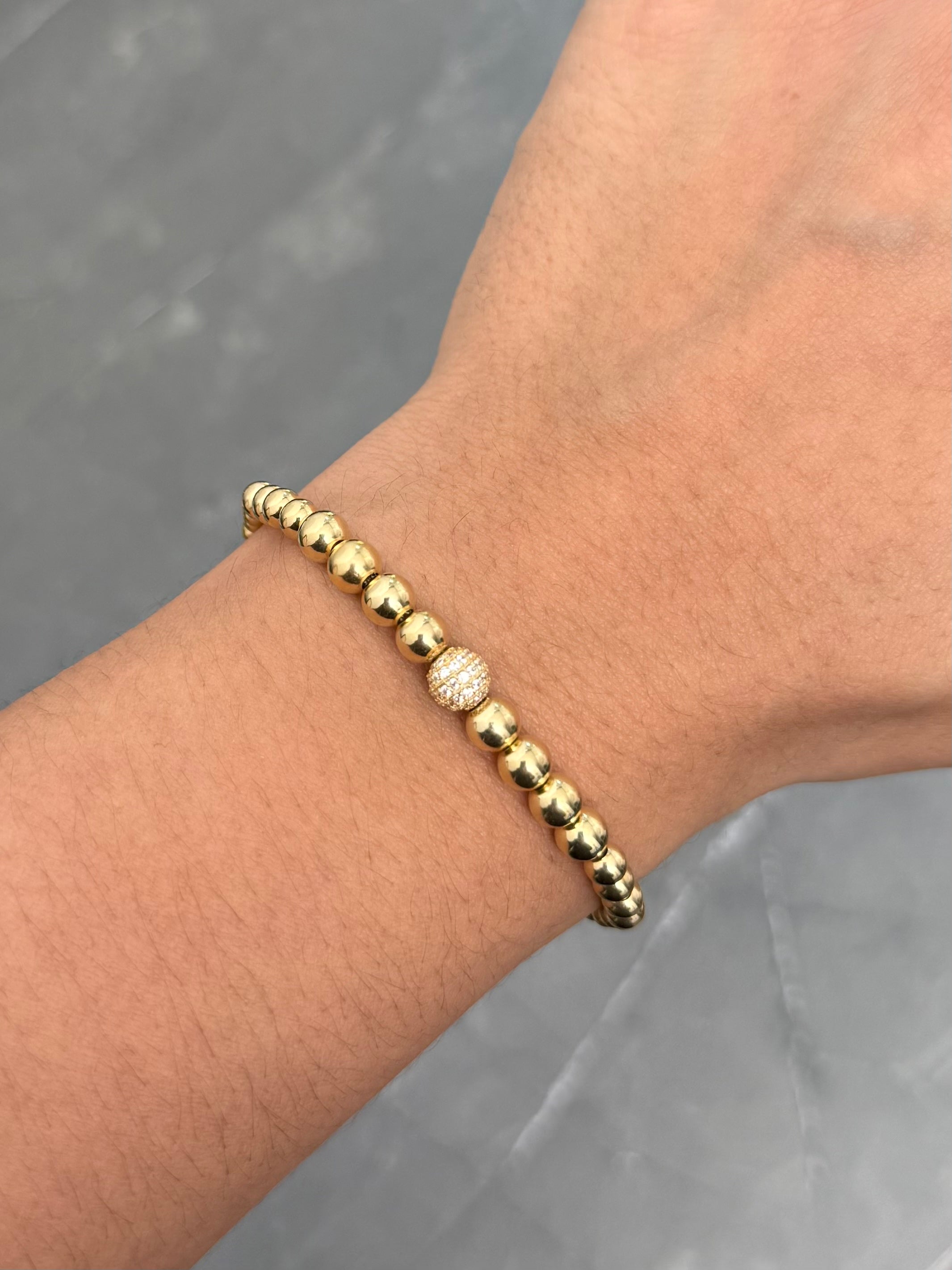 Pulsera en Hilo Beige con Bolas Lisas y Bola de Fuego 3gr — Oro Amarillo