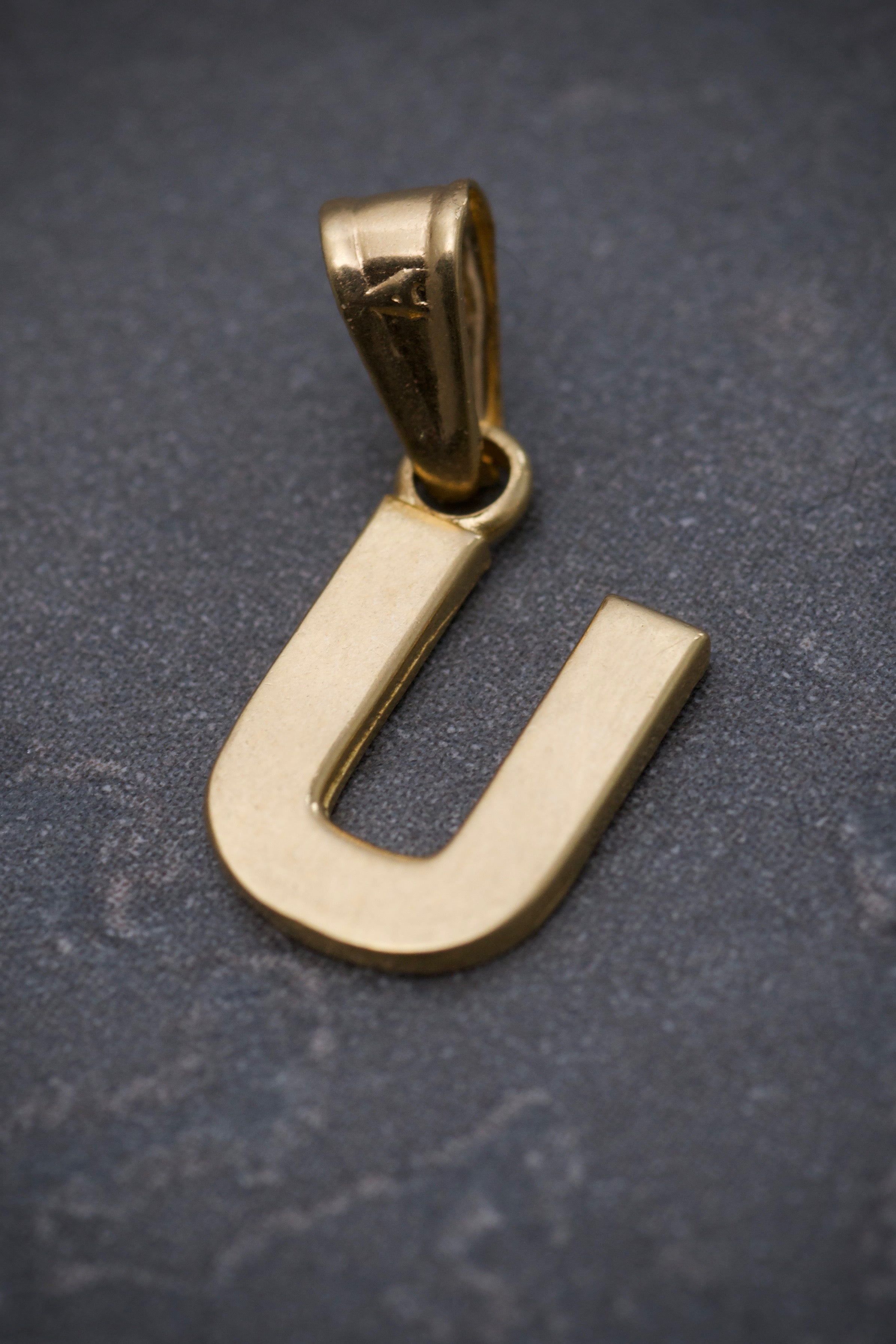 Dije de letra U liso 0.5gr / 1.2cm / Oro Amarillo Nac B