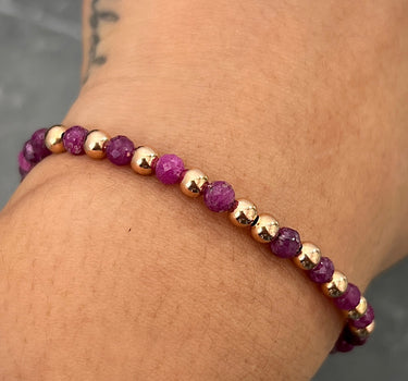 Pulsera en hilo morado con bolas lisas diamantadas y rubies 0.9gr / Oro Rosado (Joya) M
