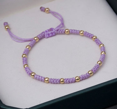 Pulsera en hilo morado con bolas lisas 0.75gr / Oro Amarillo (Joya) M