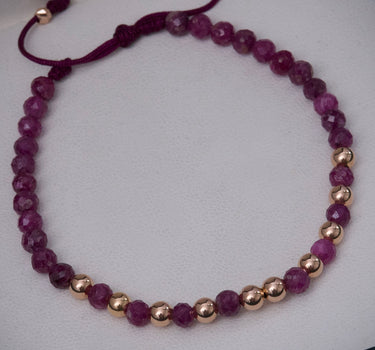 Pulsera en hilo morado con bolas lisas diamantadas y rubies 0.9gr / Oro Rosado (Joya) M