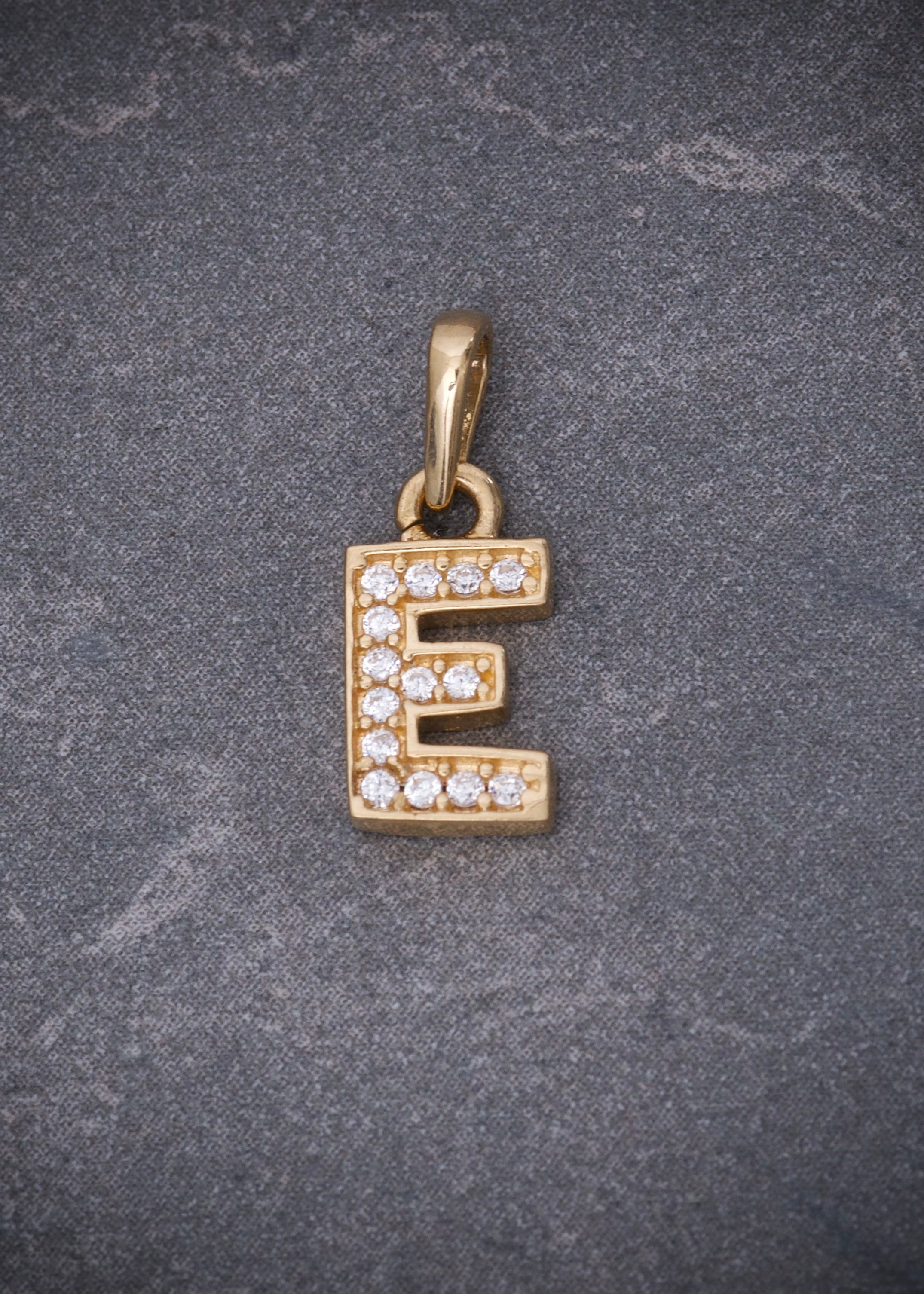 Dije letra e con swarovski blanco 0.85gr / Largo 1.4cm / Oro Amarillo Nac B