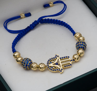 Pulsera de hilo azul con herraje de mano hamsa,  bolas de fuego y bolas diamantadas 9.75gr / Oro Amarillo (Joya) M