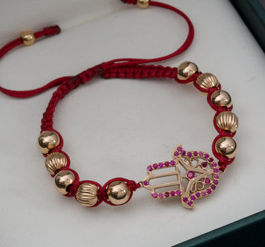 Pulsera de hilo rojo con herraje de mano hamsa y bolas diamantadas y lisas 5.3gr / Oro Rosado (Joya) M