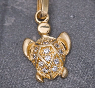 Dije tortuga con swarovski blanco 0.8gr / Largo 1.6cm / Oro Amarillo Nac M