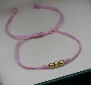 Pulsera en hilo rosa con bolas lisas 4mm 0.3gr / Oro Amarillo (Joya) M