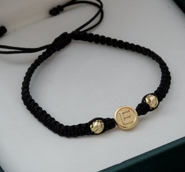 Pulsera en hilo negro con herraje de letra E y bolas diamantadas 0.65gr / Oro Amarillo Nac (Joya) M