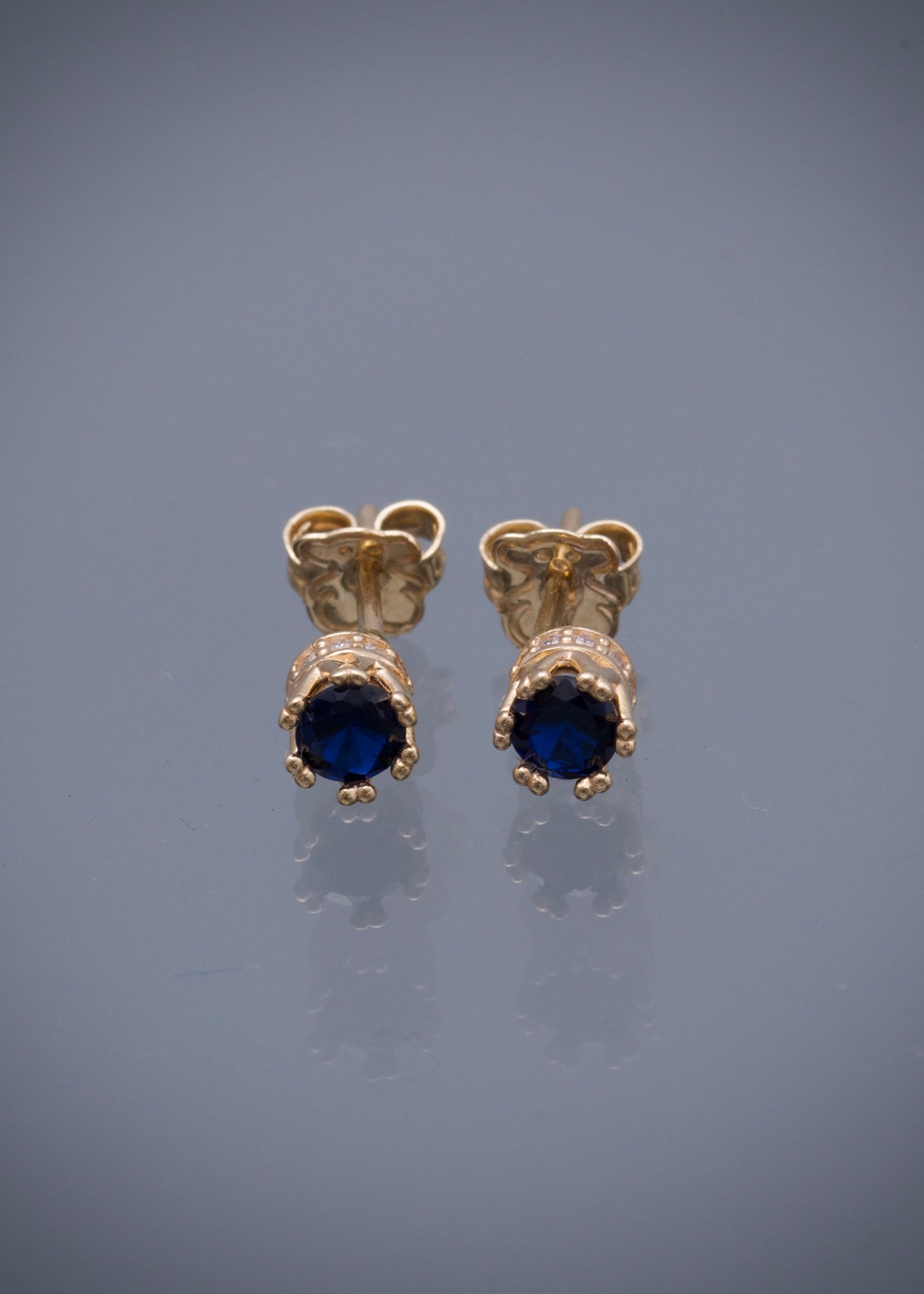 Topos corona con swarovski azul y blanco 1.6gr / Largo 0.4cm / Oro Amarillo Nac M
