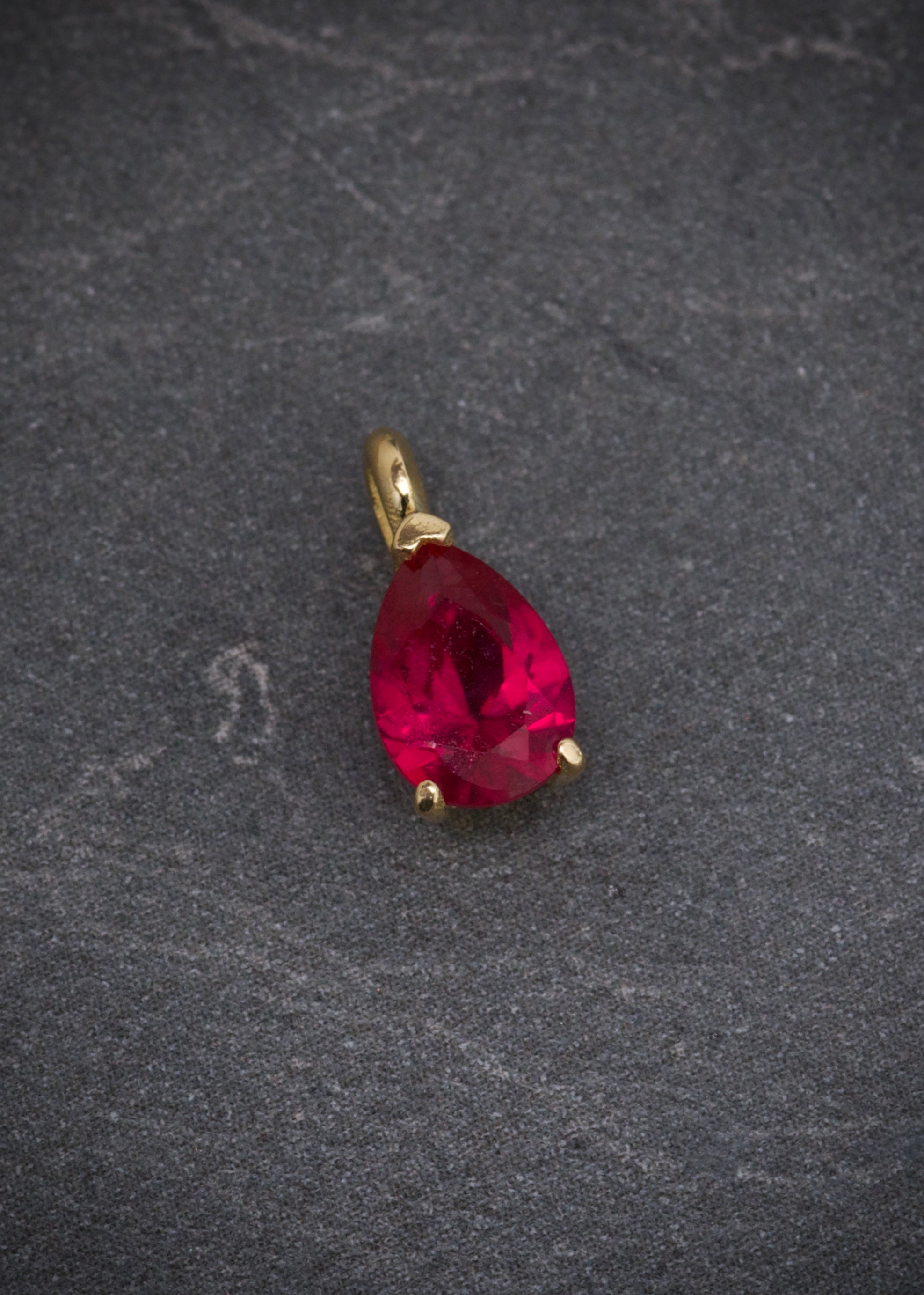 Dije con swarovski rojo 0.55gr / Largo 1cm / Oro Amarillo Nac B