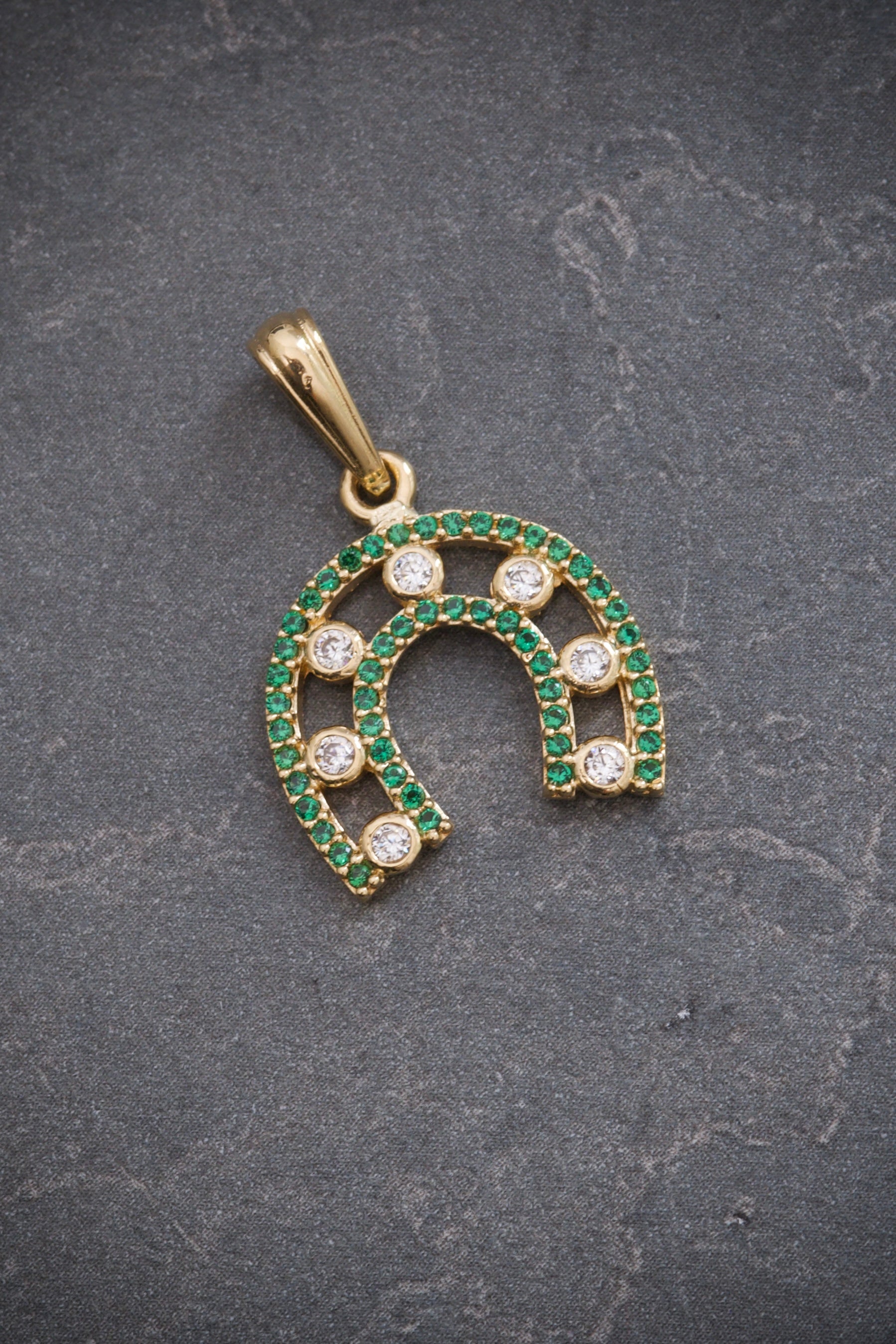 Dije herradura con swarovski blanco y verde 2.45gr / Largo 2.5cm / Oro Amarillo Nac M