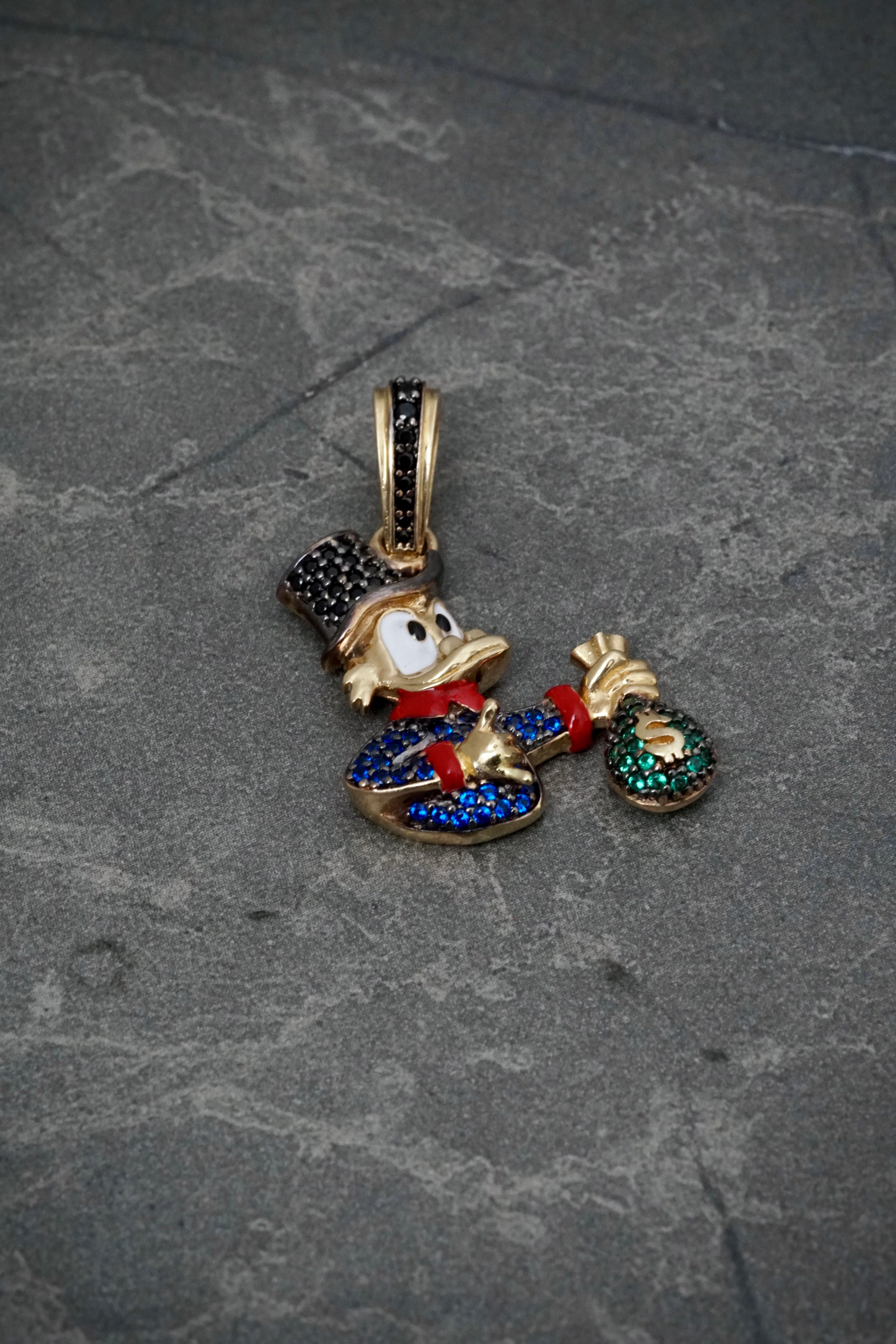 Dije tio rico con swarovski azul y negro 5.6gr / Largo 3.5cm / Oro Amarillo Nac P