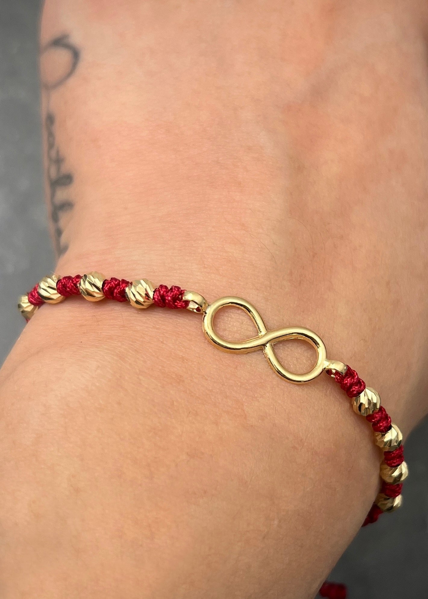 Pulsera en hilo rojo con herraje infinito y bolas diamantadas 1.1gr / Oro Amarillo (Joya) M