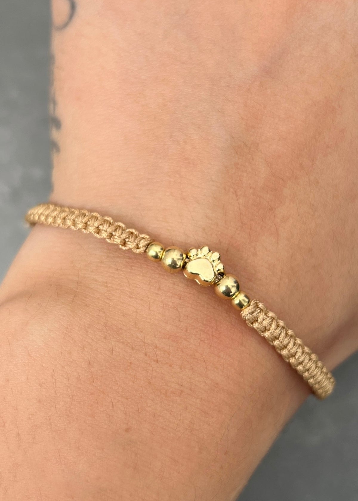 Pulsera en Hilo Beige con Herraje Huella 0.5gr — Oro Amarillo