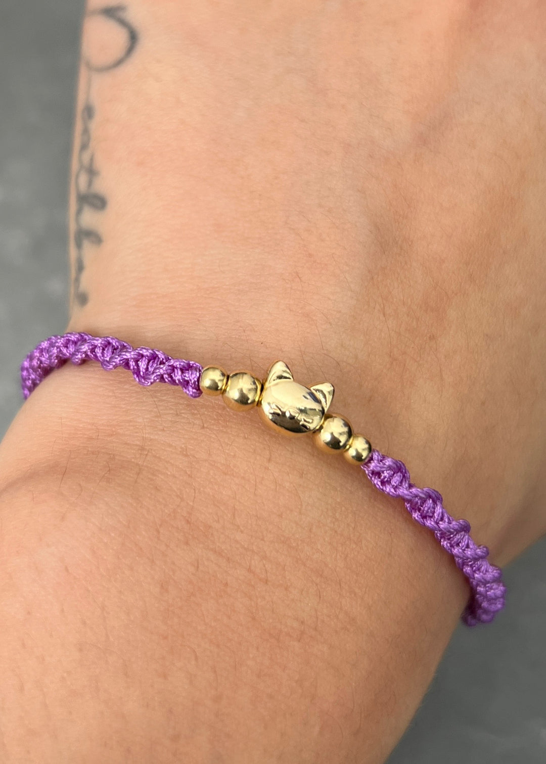 Pulsera en Hilo Morado con Herraje Gato 0.55gr — Oro Amarillo