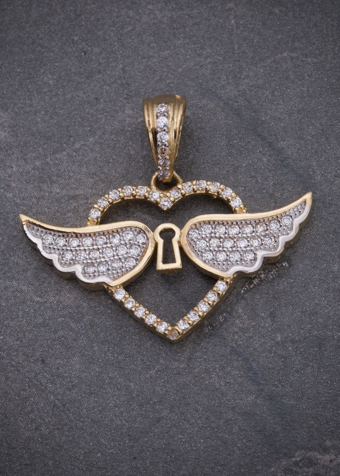 Dije corazon con alas. 2.9gr / Largo 2.2cm — Oro Amarillo