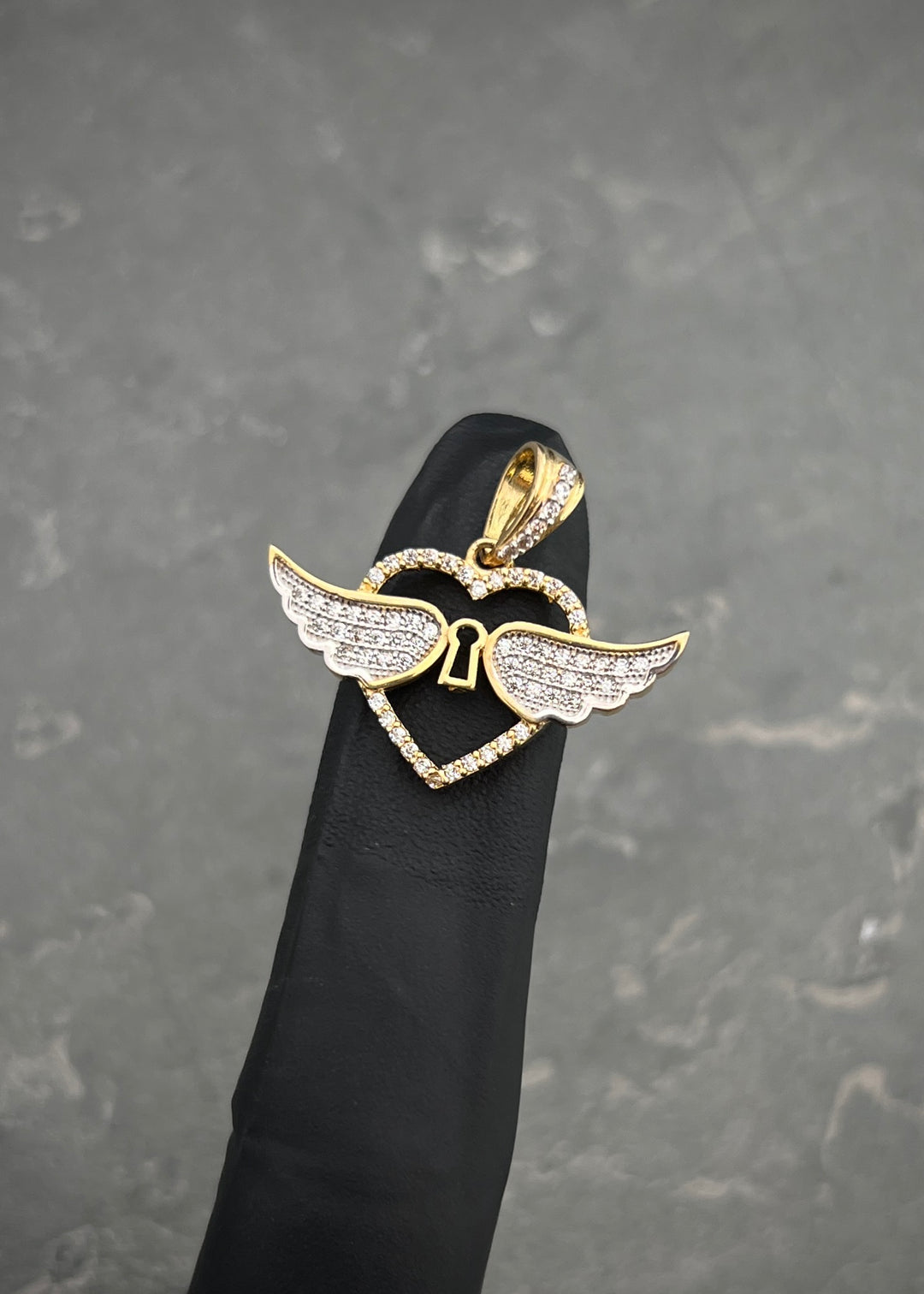 Dije corazon con alas. 2.9gr / Largo 2.2cm — Oro Amarillo