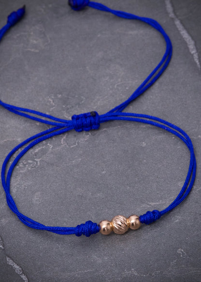 Pulsera en Hilo azul con bolas lisas y diamantada 0.35gr / Oro Rosado (Joya) M