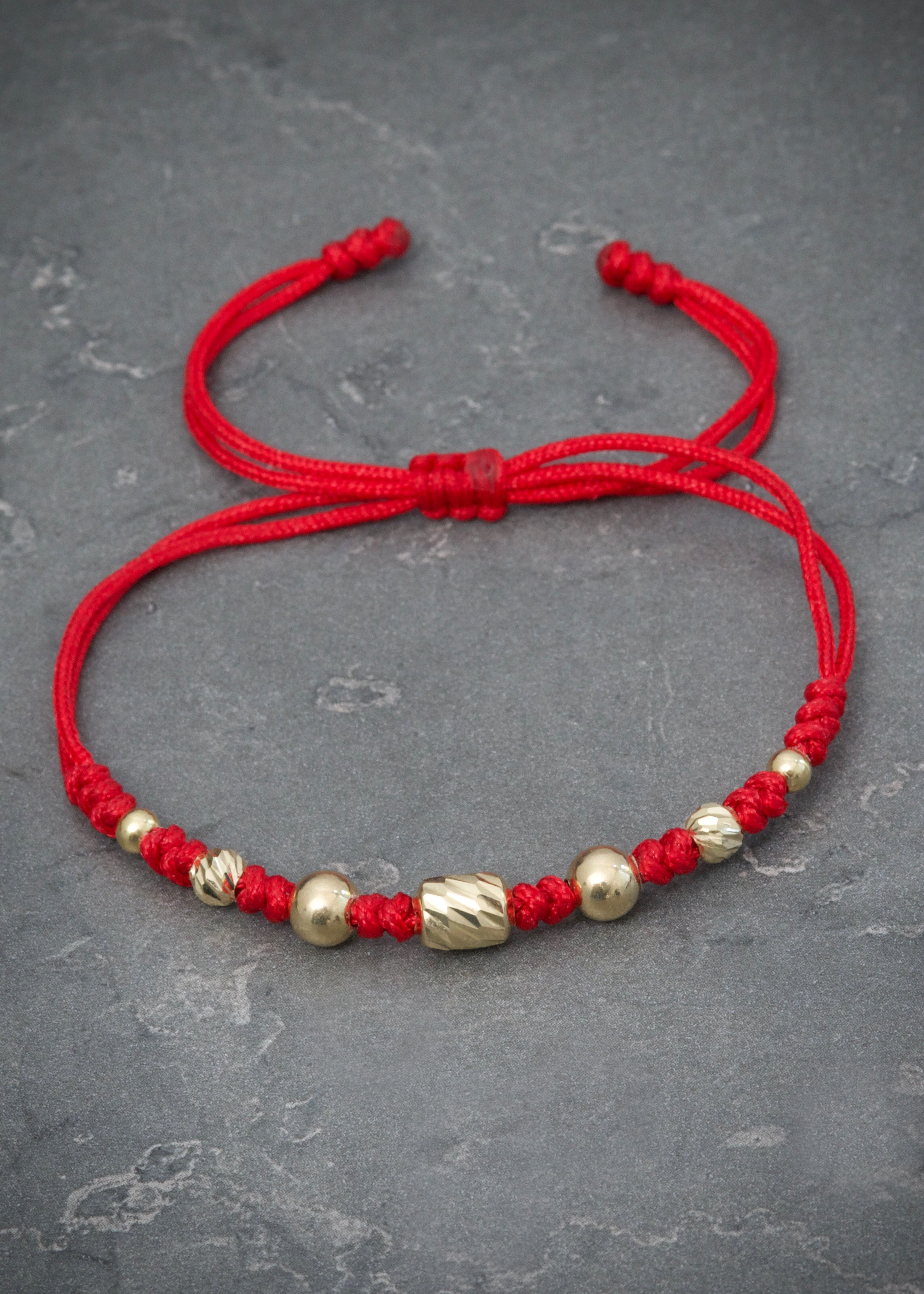 Pulsera en hilo rojo con herraje bolas lisas y diamantadas 0.75gr / Oro Amarillo (Joya) M