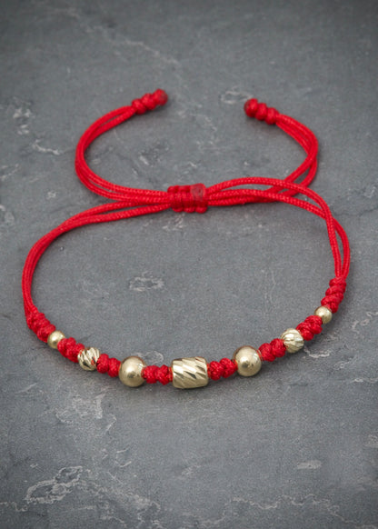 Pulsera en hilo rojo con herraje bolas lisas y diamantadas 0.75gr / Oro Amarillo (Joya) M