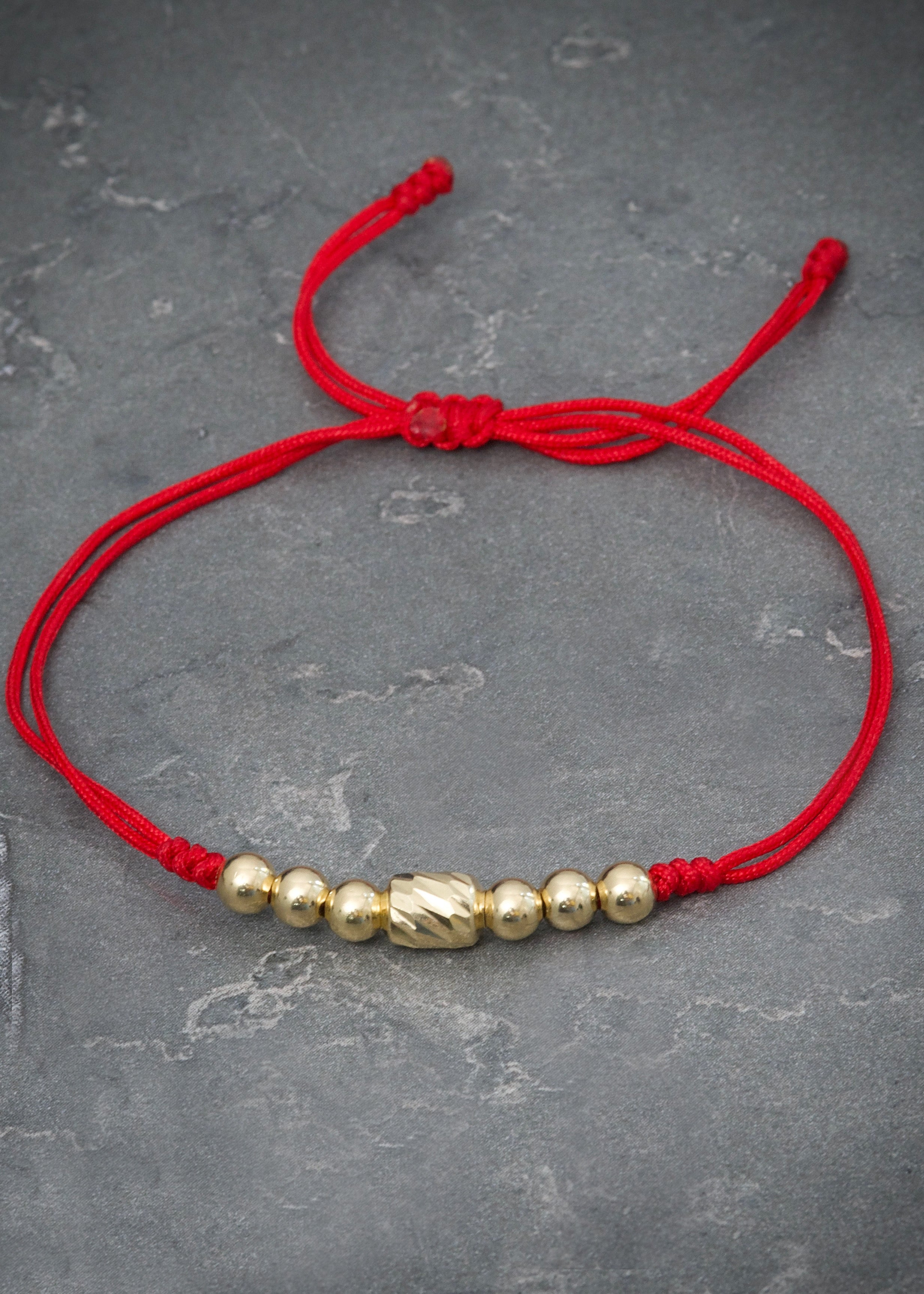 Pulsera en hilo rojo con herraje y bolas lisas 0.8gr / Oro Amarillo (Joya) M
