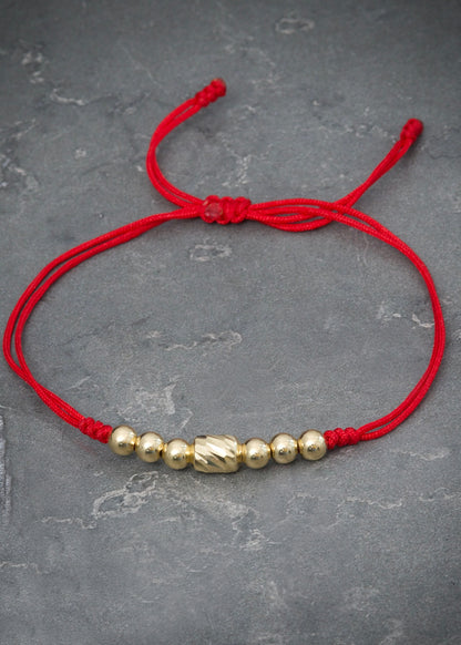 Pulsera en hilo rojo con herraje y bolas lisas 0.8gr / Oro Amarillo (Joya) M