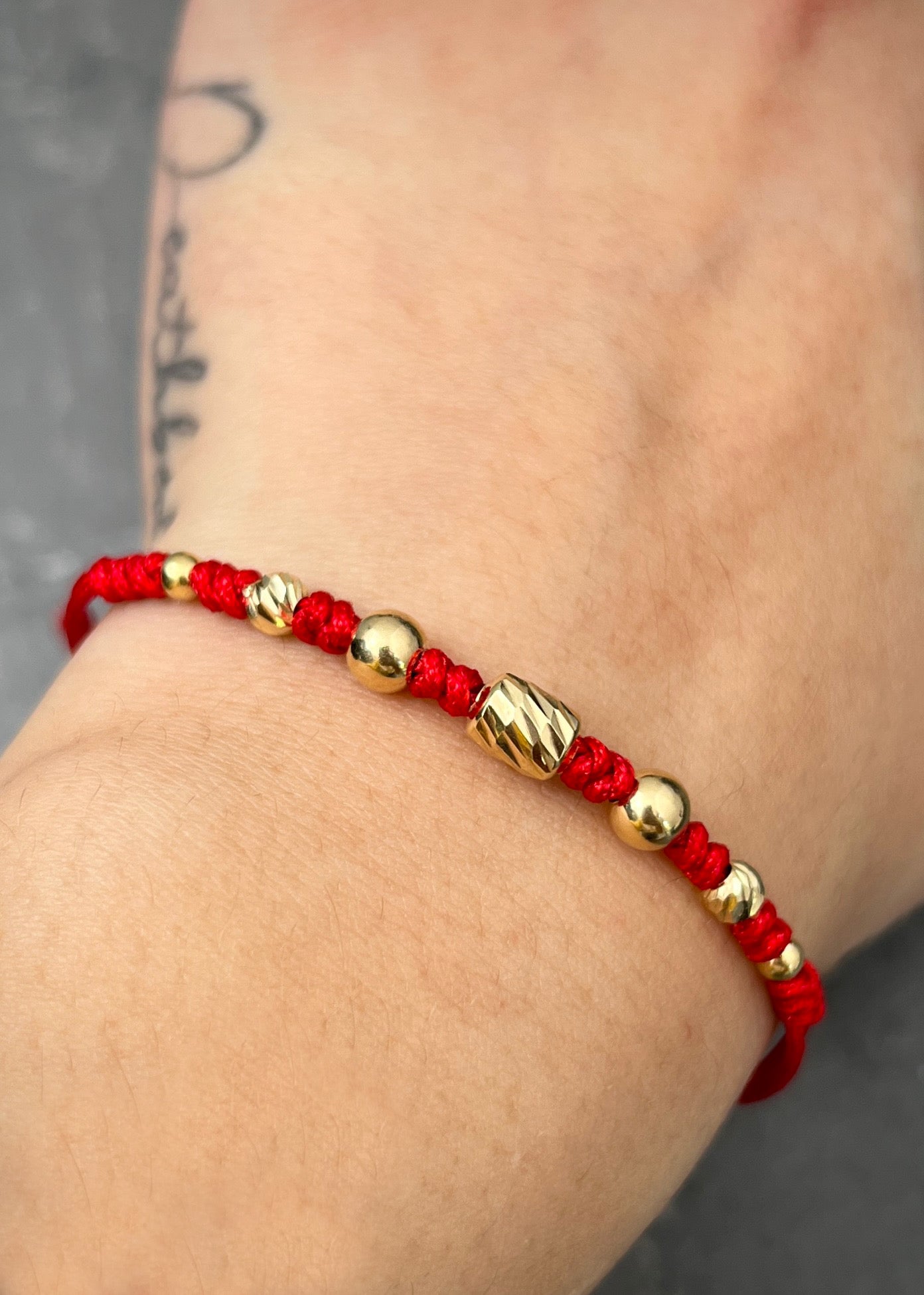 Pulsera en hilo rojo con herraje bolas lisas y diamantadas 0.75gr / Oro Amarillo (Joya) M