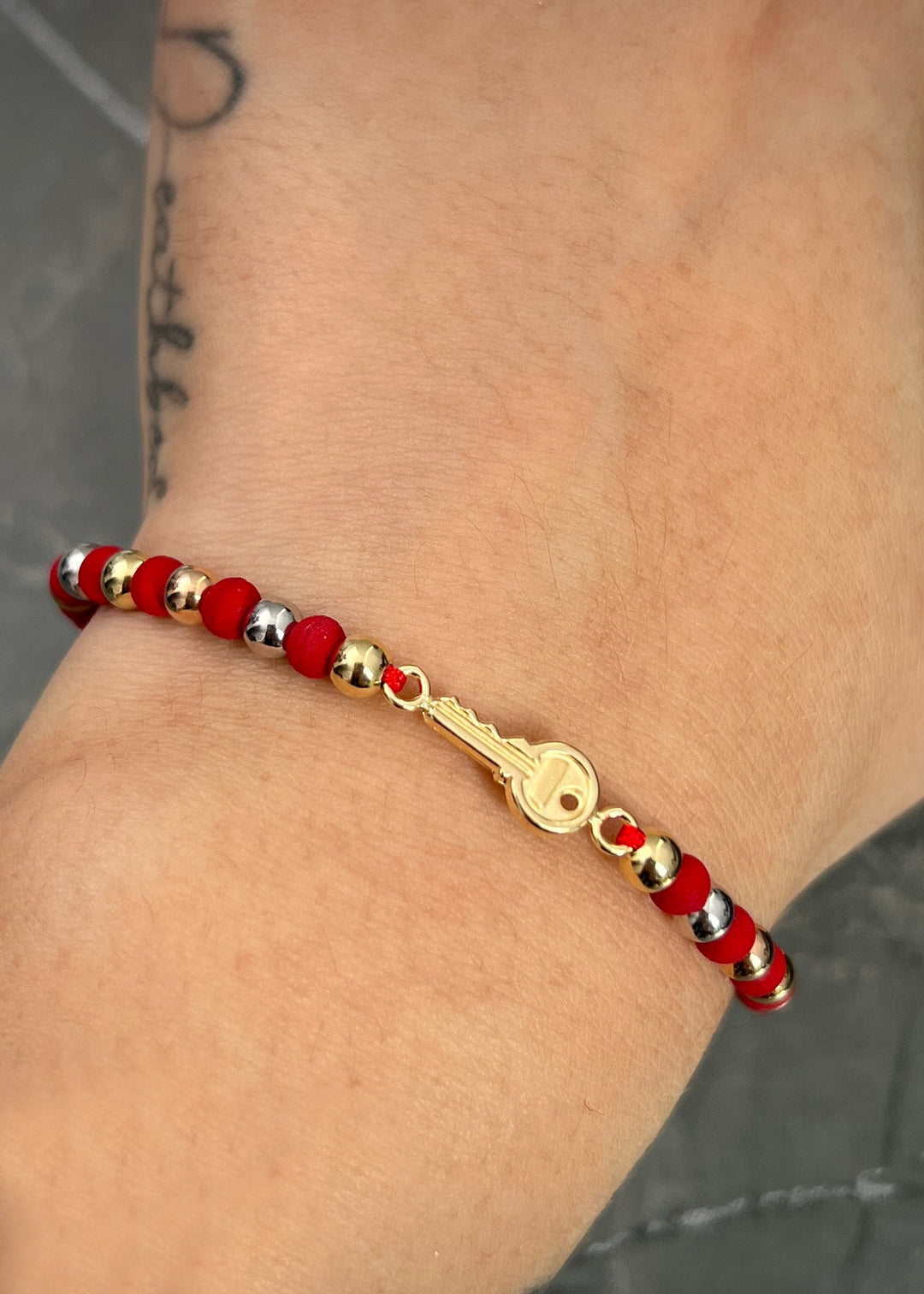 Pulsera en hilo rojo con herraje llave 1.55gr — Tres Oros