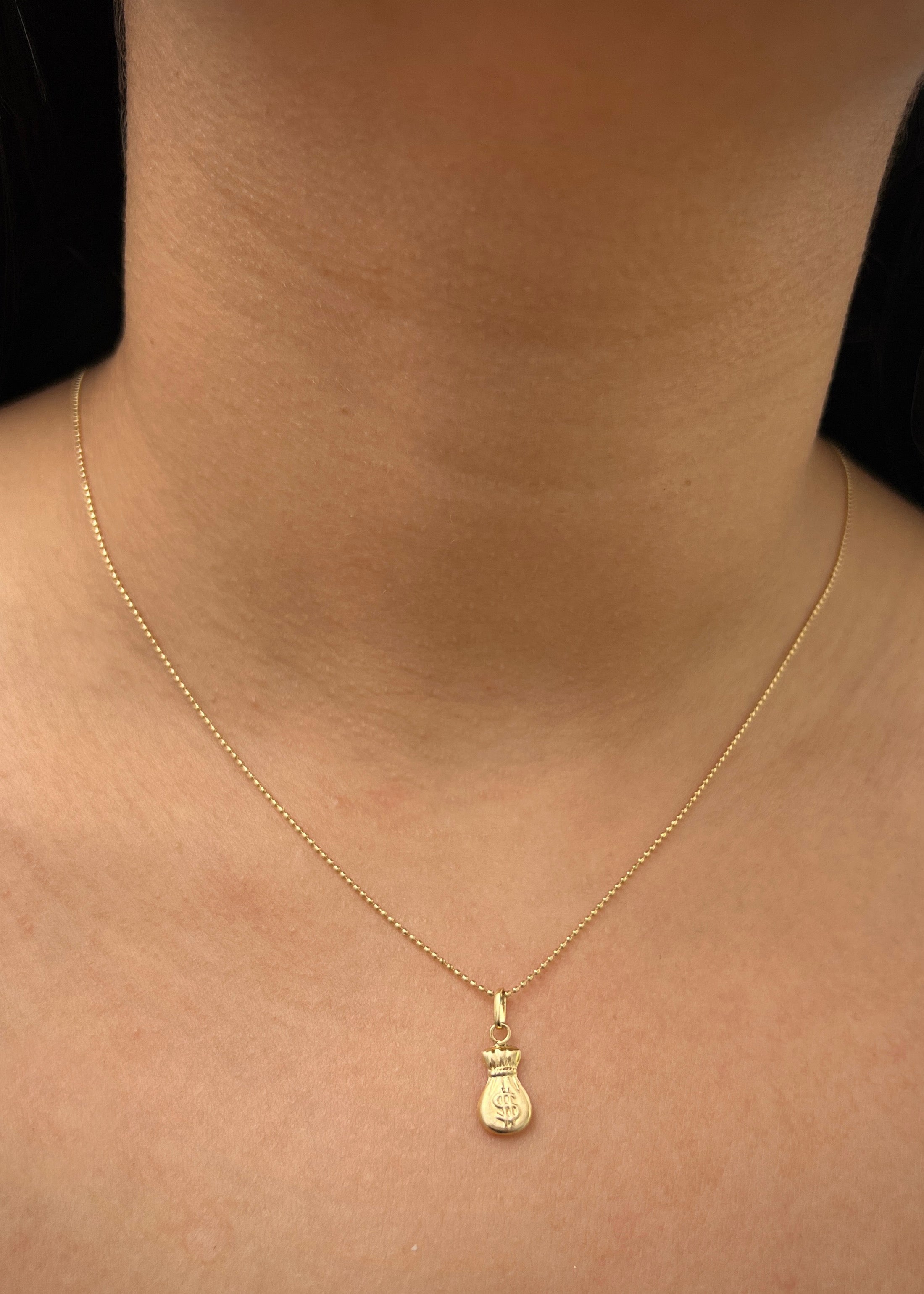 Dije bolsa de dinero 0.4gr / Largo 1.7cm / Oro Amarillo Nac M