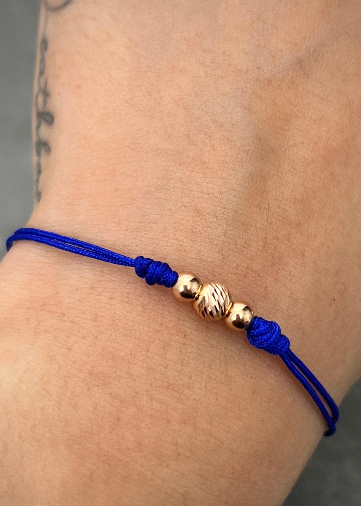 Pulsera en Hilo azul con bolas lisas y diamantada 0.35gr / Oro Rosado (Joya) M