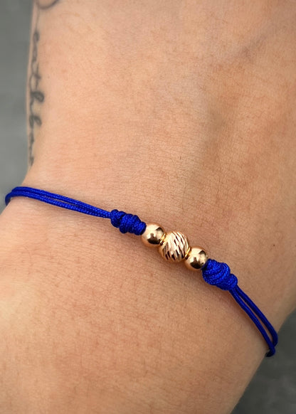 Pulsera en Hilo azul con bolas lisas y diamantada 0.35gr / Oro Rosado (Joya) M