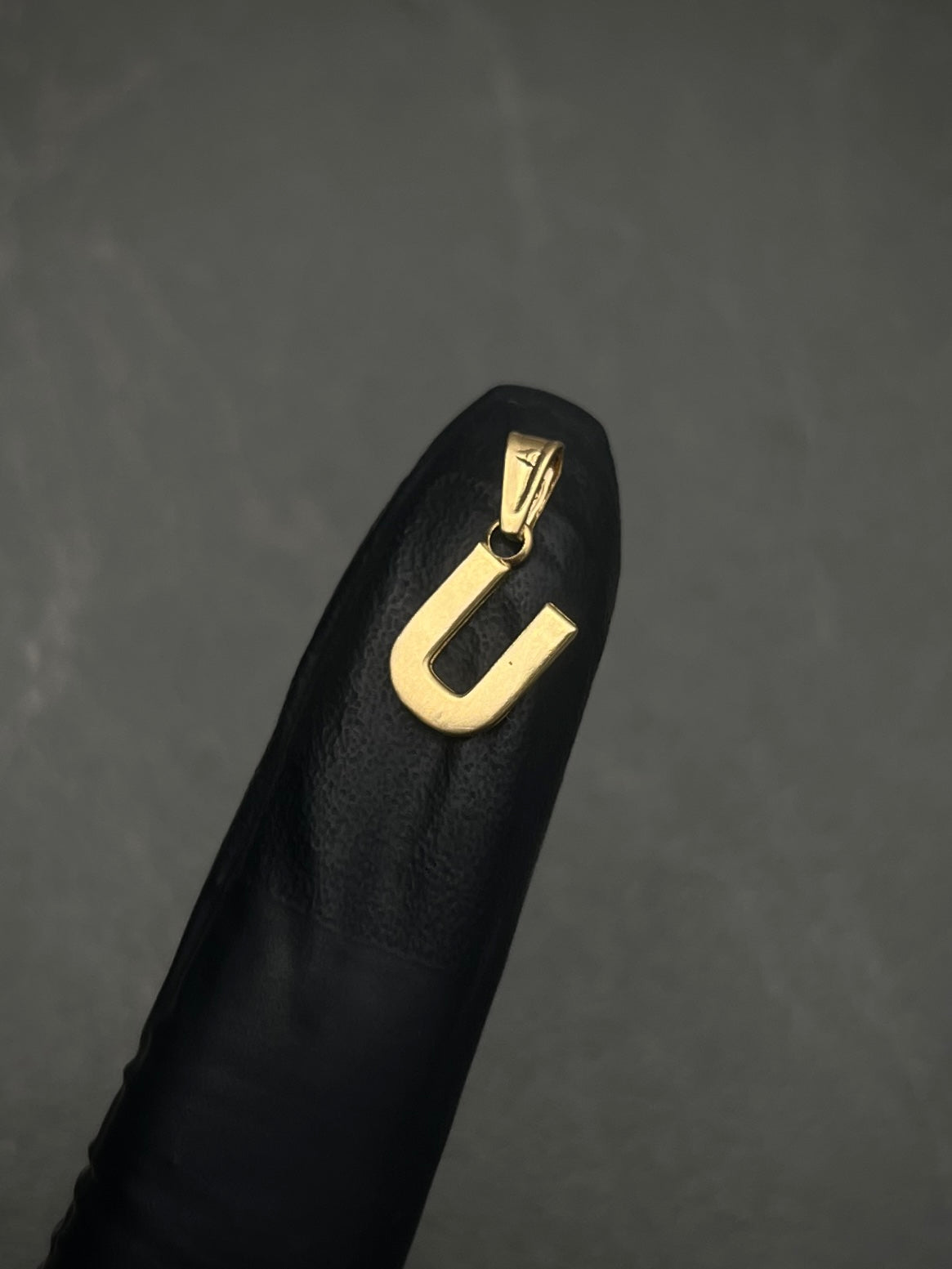 Dije de letra U liso 0.5gr / 1.2cm / Oro Amarillo Nac B
