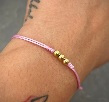 Pulsera en hilo rosa con bolas lisas 4mm 0.3gr / Oro Amarillo (Joya) M