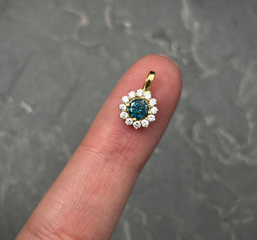 Dije flor con 30pts de diamante azul y 18pts de diamante blanco 0.75gr / Largo 1.2cm / Oro Amarillo Nac (Joya) B