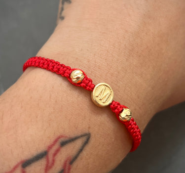 Pulsera en hilo rojo con herraje de letra M y bolas diamantadas 0.65gr / Oro Amarillo Nac (Joya) M