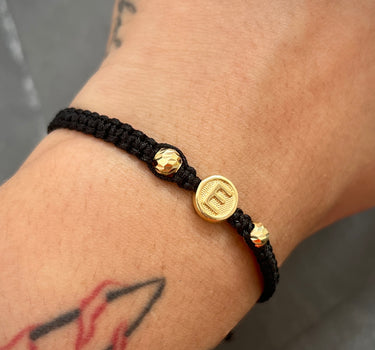 Pulsera en hilo negro con herraje de letra E y bolas diamantadas 0.65gr / Oro Amarillo Nac (Joya) M