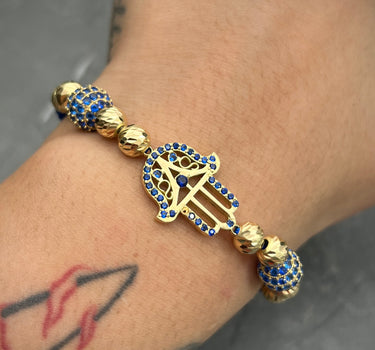 Pulsera de hilo azul con herraje de mano hamsa,  bolas de fuego y bolas diamantadas 9.75gr / Oro Amarillo (Joya) M