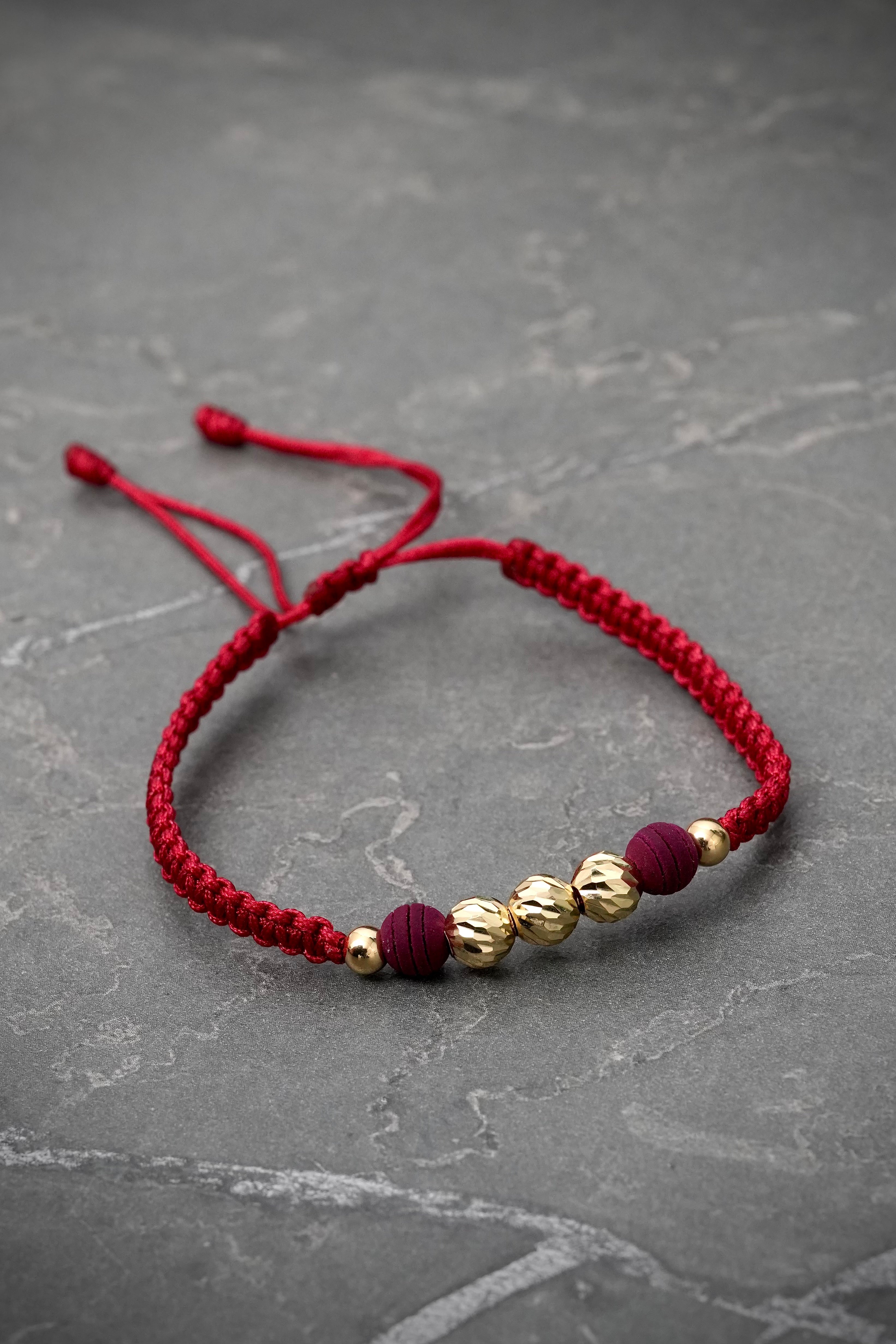 Pulsera en hilo vino tinto con bolas diamantadas y lisas 0.75gr / Oro Amarillo (Joya) M