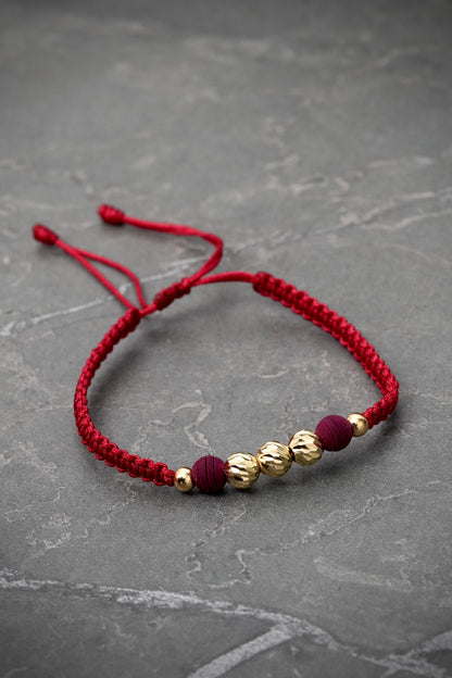 Pulsera en hilo vino tinto con bolas diamantadas y lisas 0.75gr / Oro Amarillo (Joya) M